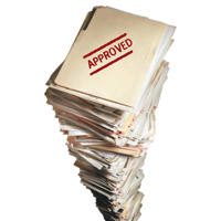 stack of file folders; top folder stamped in red - approved
